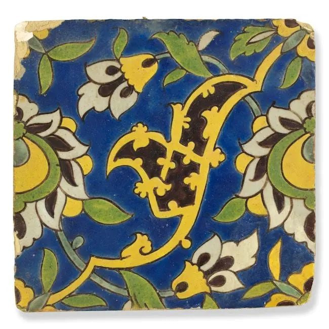 A Safavid cuerda seca pottery tile Persia, 17th Century: A Safavid cuerda seca pottery tile Persia, 17th Century of square form, decorated in cobalt-blue, green and yellow with black outline with swirling vines terminating in flowerheads and a half palmette