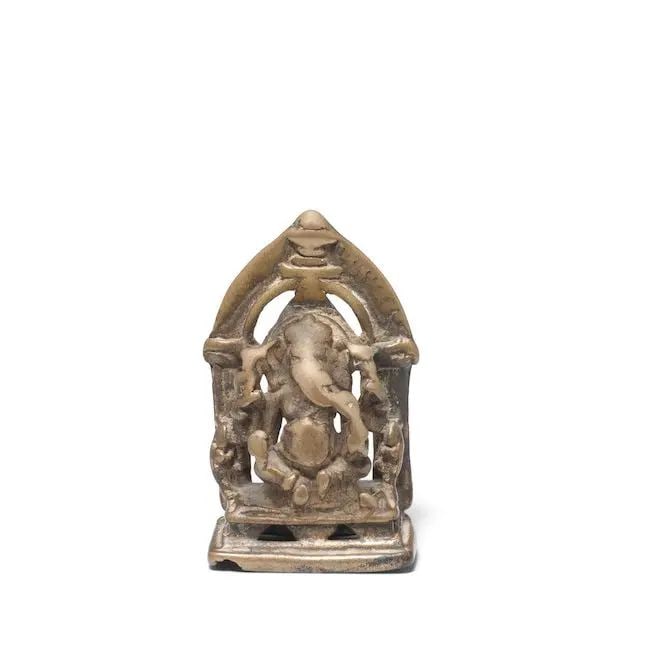 A bronze figure of Ganesh North India, 16th Century: A bronze figure of Ganesh North India, 16th Century seated on a rectangular throne with arched back 7.2 cm. high Footnotes: Provenance Private UK Collection, London, acquired at John Siudmak Asian Art