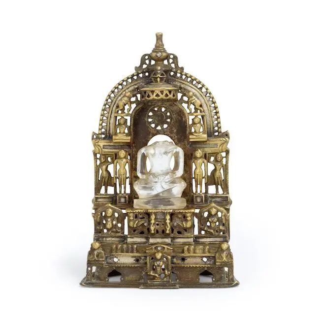 A Jain silver-inlaid brass shrine Western India, 15th/ 16th Century: A Jain silver-inlaid brass shrine Western India, 15th/ 16th Century in the form of a throne supported by two addorsed lions and surrounded by jina and attendants, the canopy supported by two elephants