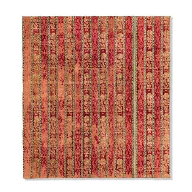A Mughal velvet panel North India, 17th Century: A Mughal velvet panel North India, 17th Century of rectangular form, woven red, blue and cream silk with a series of wide vertical bands alternately containing a repeat design of floral spays and flor
