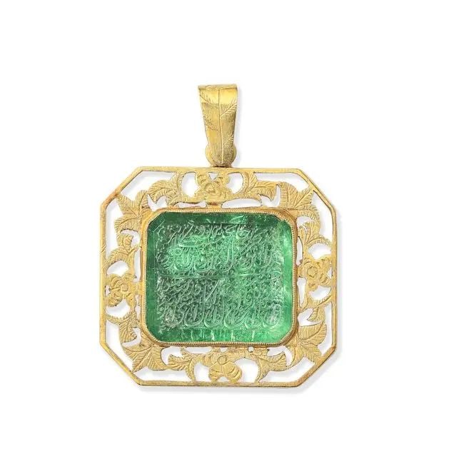 A calligraphic emerald-set gold pendant North India, 19th/ 20th Century: A calligraphic emerald-set gold pendant North India, 19th/ 20th Century the green emerald of rectangular form with facetted, cut corners, engraved with two lines of inscription in nasta'liq on a groun