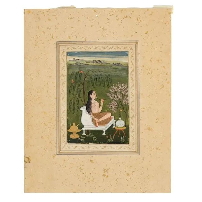 A courtesan seated smoking a hookah beneath a drooping willow tree Deccan, 18th Century: A courtesan seated smoking a hookah beneath a drooping willow tree Deccan, 18th Century gouache and gold on paper, laid down on an album page with gilt-decorated borders, verso a calligraphic exercise