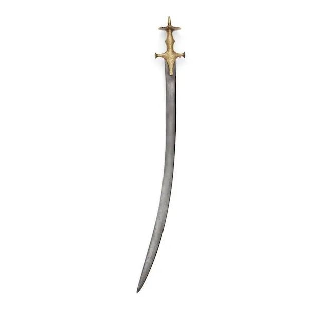A gold koftgari steel-hilted sword (sirohi tulwar) North India, 18th/ 19th Century: A gold koftgari steel-hilted sword (sirohi tulwar) North India, 18th/ 19th Century the curved steel blade with flattened spine becoming double edged towards the point, the hilt profusely decorated in 