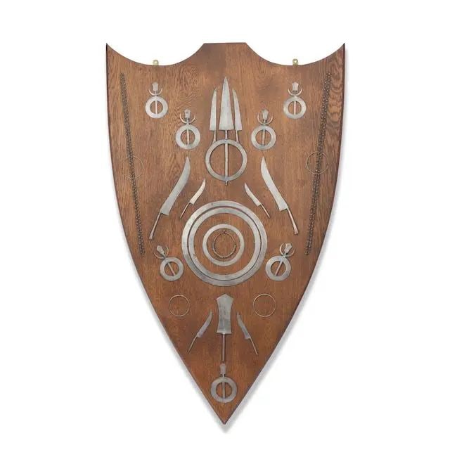 A collection of steel Quoits, regimental turban ornaments (pugri), a gajgah and other accoutreme...: A collection of steel Quoits, regimental turban ornaments (pugri), a gajgah and other accoutrements of the Sikh Akali-Nihang mounted on a wood shield Punjab, second half of the 19th Century comprising
