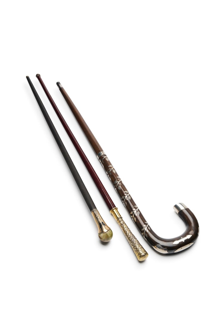 Three walking sticks, English, 20th century (3): Three walking sticks, English, 20th century The impressive crook-handled walking stick inlaid with decorative silver emblems including heraldic shields and a spiralling foliate band, 89.0 cm long; the