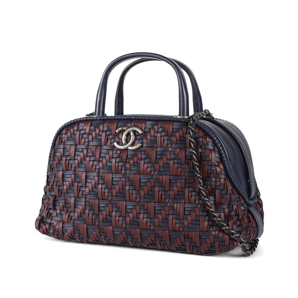 Chanel, année 2016. Sac double poignée en cuir agneau tressé marine et bordeaux. ...: Chanel, année 2016. Sac double poignée en cuir agneau tressé marine et bordeaux. Chanel, 2016. Double-handle bag in navy and burgundy braided lambskin leather. Directeur artistique: Kar