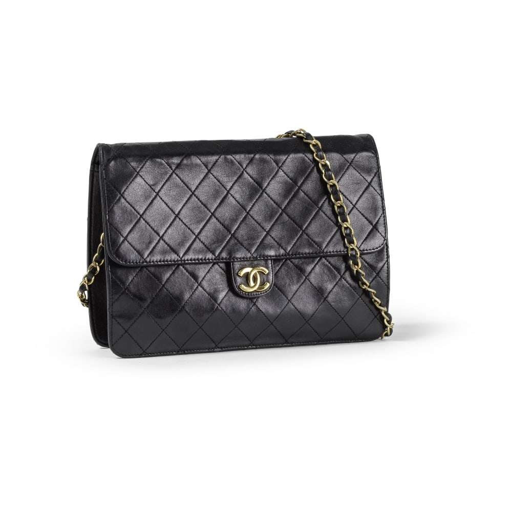 Chanel, circa 1990. Pochette Classique en cuir agneau matelassé noir. Chanel, circa 1990. C...: Chanel, circa 1990. Pochette Classique en cuir agneau matelassé noir. Chanel, circa 1990. Classic clutch in black quilted lambskin leather. Anse d'épaule en métal doré entrelac