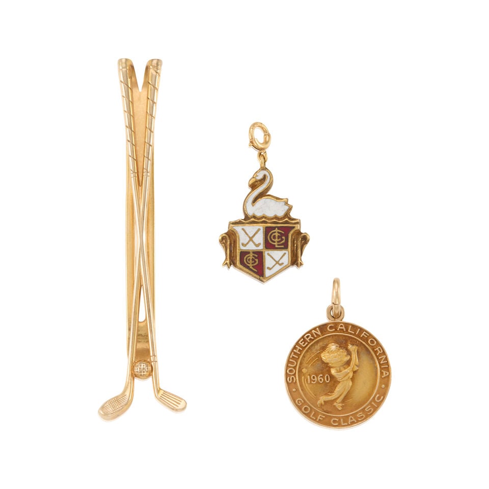 GROUP OF 10K GOLD ITEMS: GROUP OF 10K GOLD ITEMS • One charm of 10k yellow gold, measures 3/4 x 3/4 in. • One charm of 10k yellow gold with white and red enamel, measures 3/4 x 1/2 in. • One money clip of