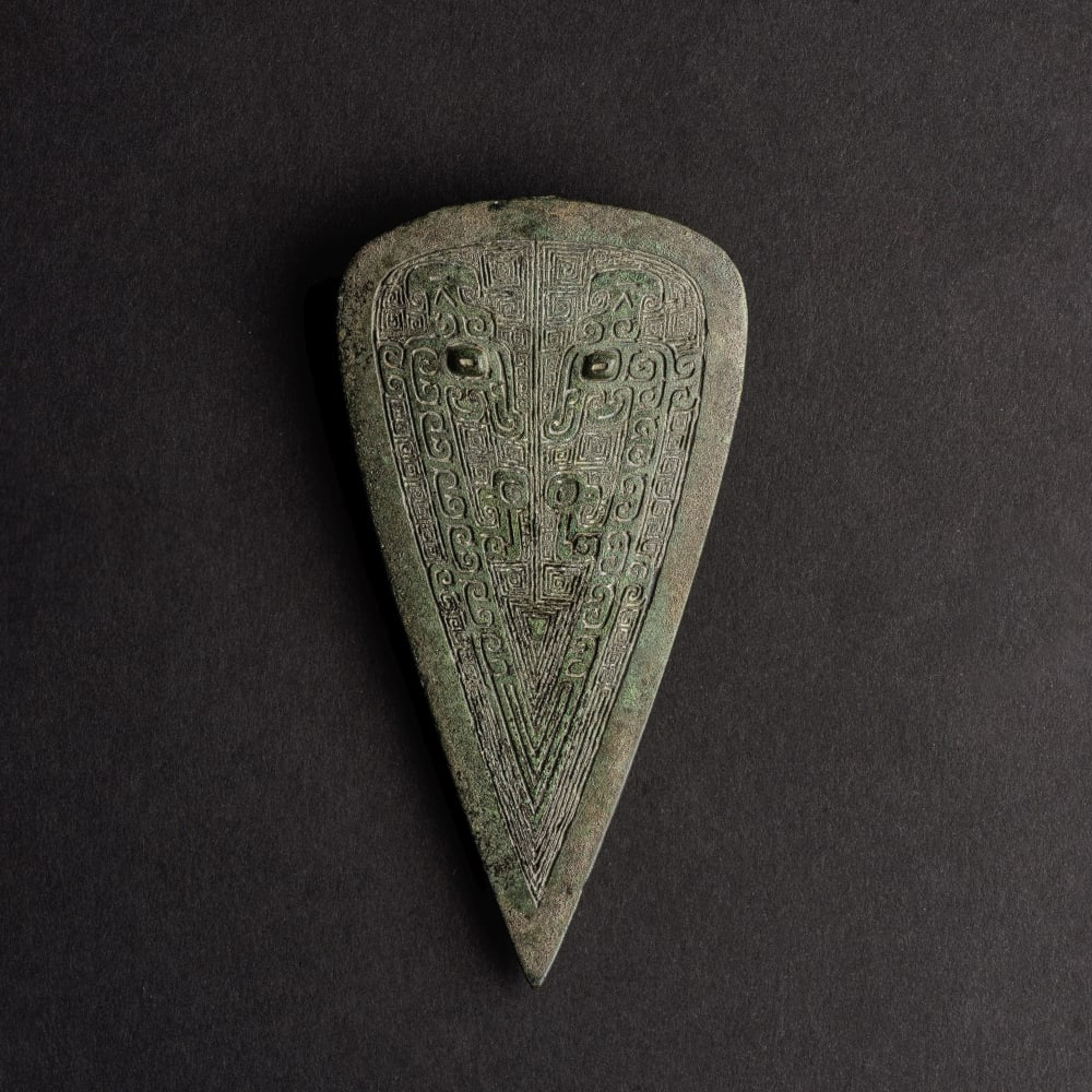 RARE ORNEMENT DE HARNAIS EN BRONZE Fin de la dynastie Shang, vers XIe siècle av. J.-C. (2): RARE ORNEMENT DE HARNAIS EN BRONZE Fin de la dynastie Shang, vers XIe siècle av. J.-C. A RARE ARCHAIC BRONZE HARNESS FITTING Late Shang Dynasty, ca. 11th century BC Of shield shape, finely cast i