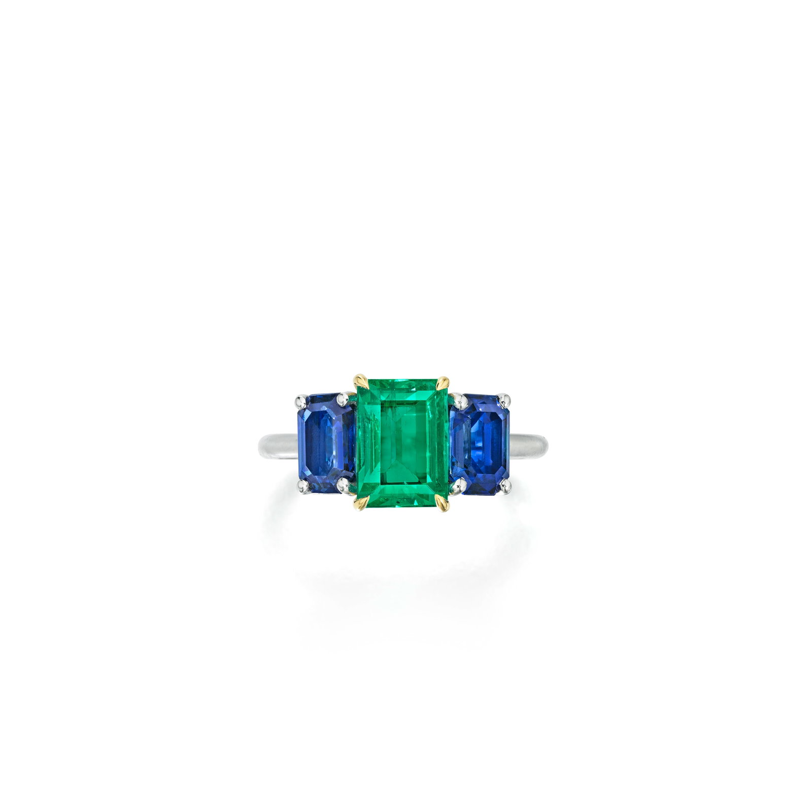 AN EMERALD AND SAPPHIRE RING: AN EMERALD AND SAPPHIRE RING Centering an emerald-cut emerald, weighing 1.89 carats, flanked by two emerald-cut sapphires; estimated total sapphire weight 1.30 carats; mounted in platinum and 18K