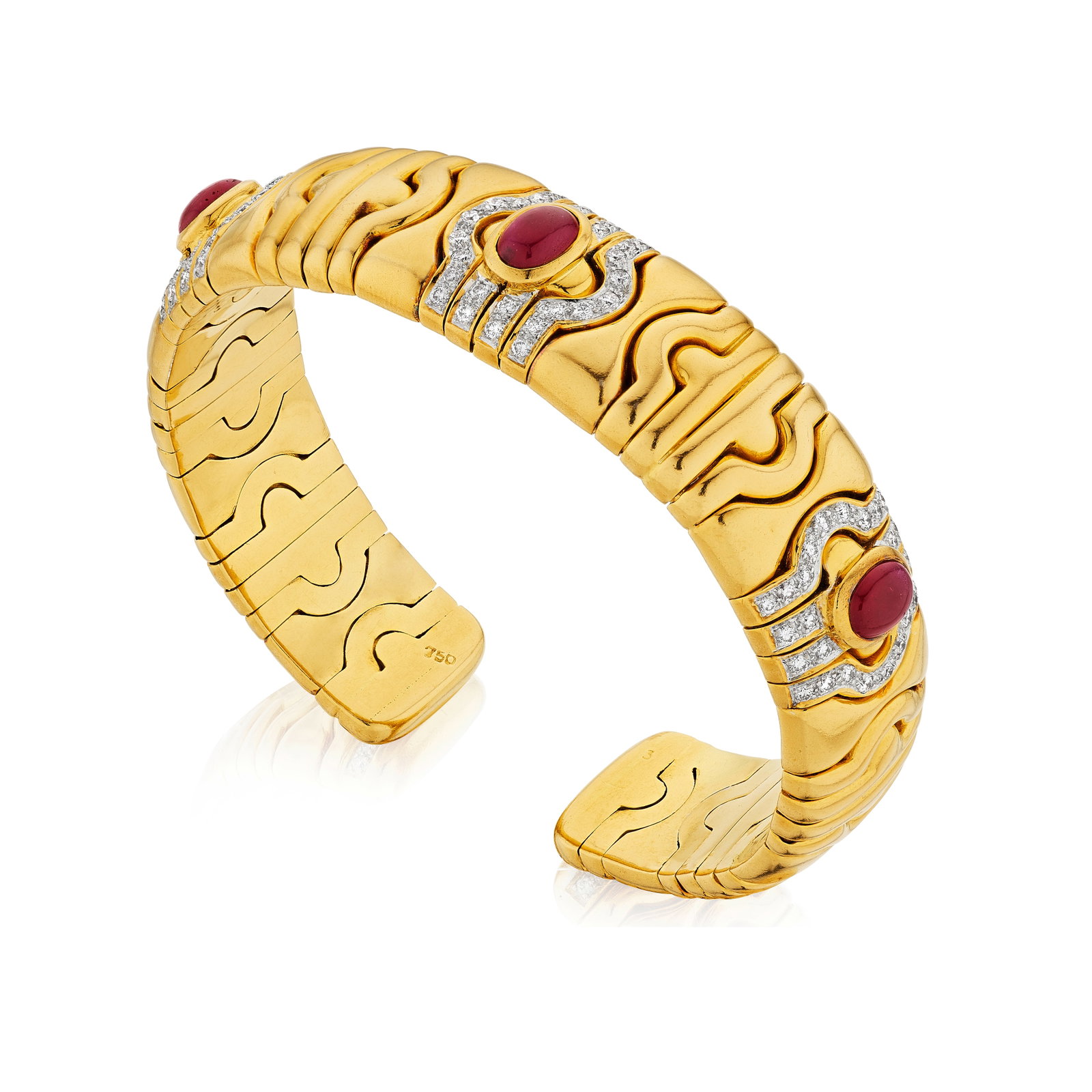 A RUBY AND DIAMOND CUFF: A RUBY AND DIAMOND CUFF Designed as a cuff, centering three oval-shaped cabochon rubies, and further enhanced by round brilliant-cut diamonds; estimated total diamond weight 1.30 carats; mounted in