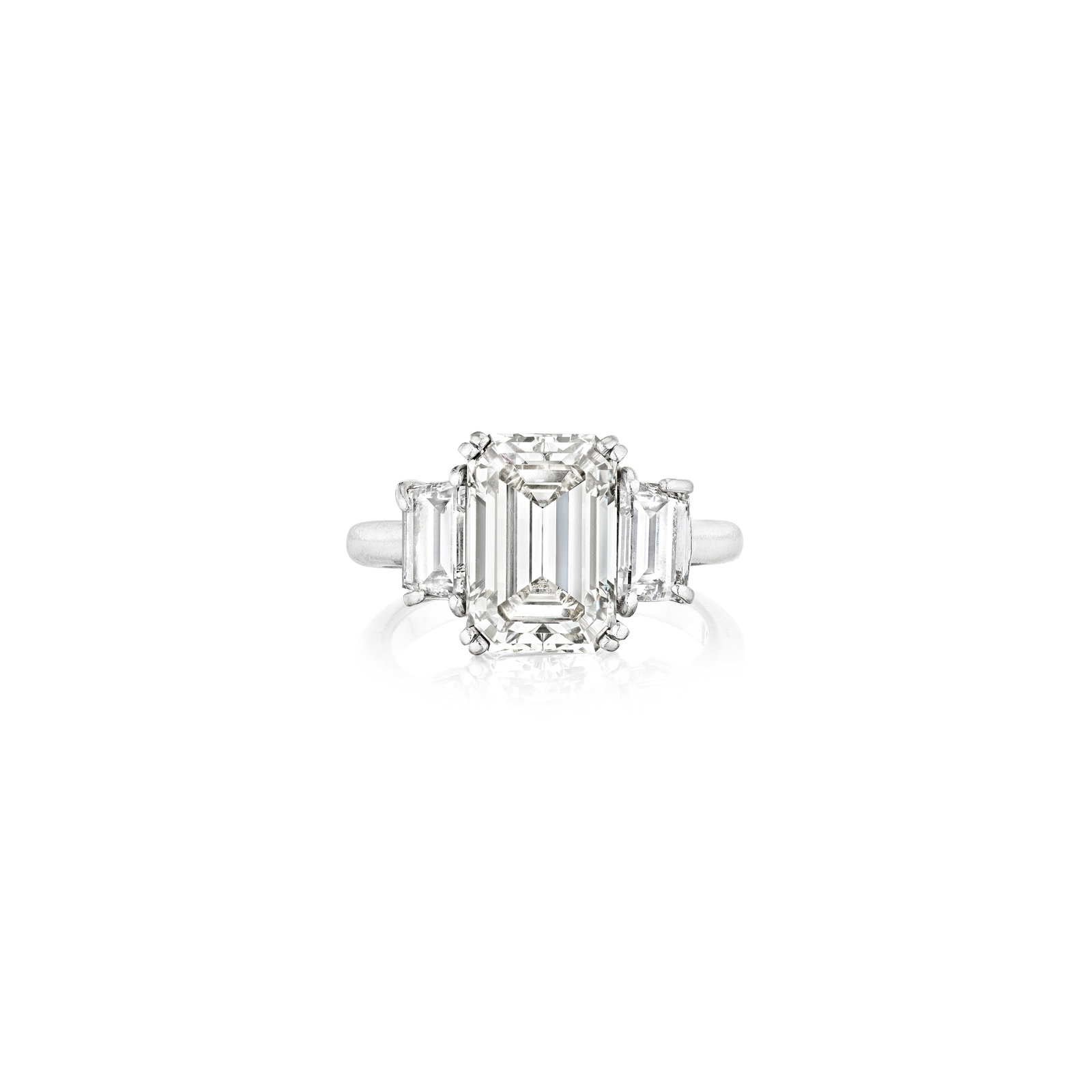 A DIAMOND RING: A DIAMOND RING Centering an emerald-cut diamond, weighing 5.01 carats, flanked by two tapered baguette-cut diamonds; estimated remaining diamond weight 1.25 carats; mounted in platinum; size 7 with