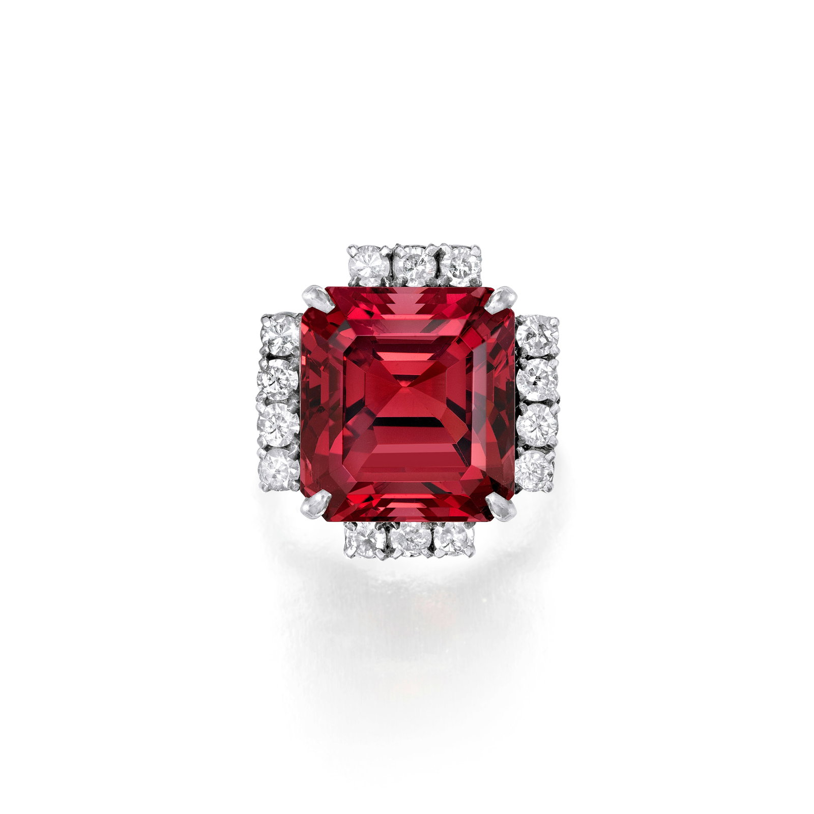A SPINEL AND DIAMOND RING, CIRCA 1950: A SPINEL AND DIAMOND RING, CIRCA 1950 Centering an emerald-cut spinel, weighing 18.78 carats, within a partial surround of round brilliant-cut diamonds; mounted in silver; size 4¾ Footnotes: