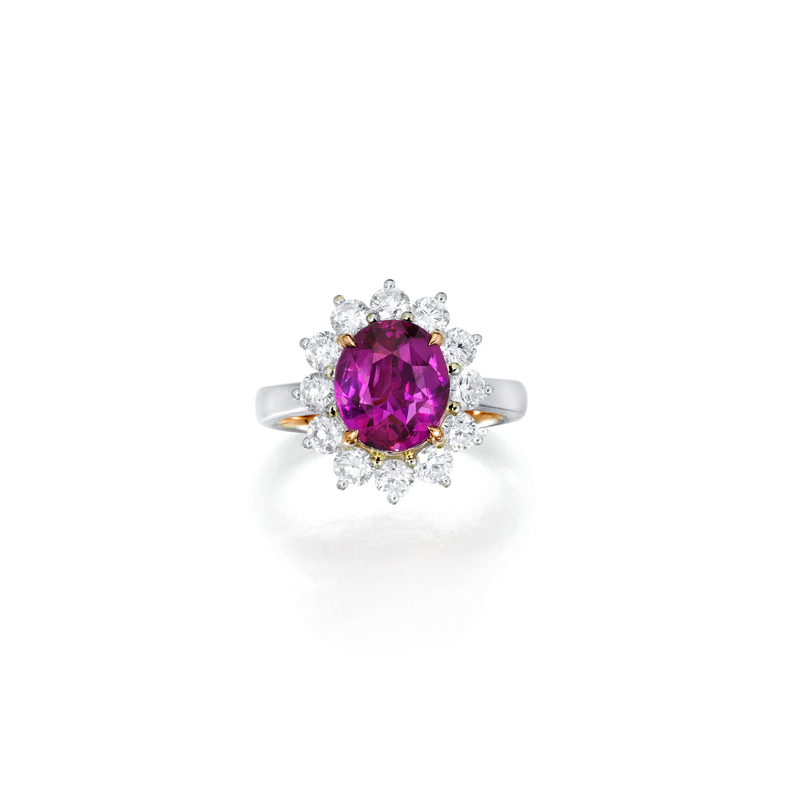 A PINK SAPPHIRE RING: A PINK SAPPHIRE RING Centering an oval-shaped pink sapphire, weighing 3.05 carats, surrounded by round brilliant-cut diamonds; mounted in 18K white and pink gold; size 4¾ Footnotes: Accompanied