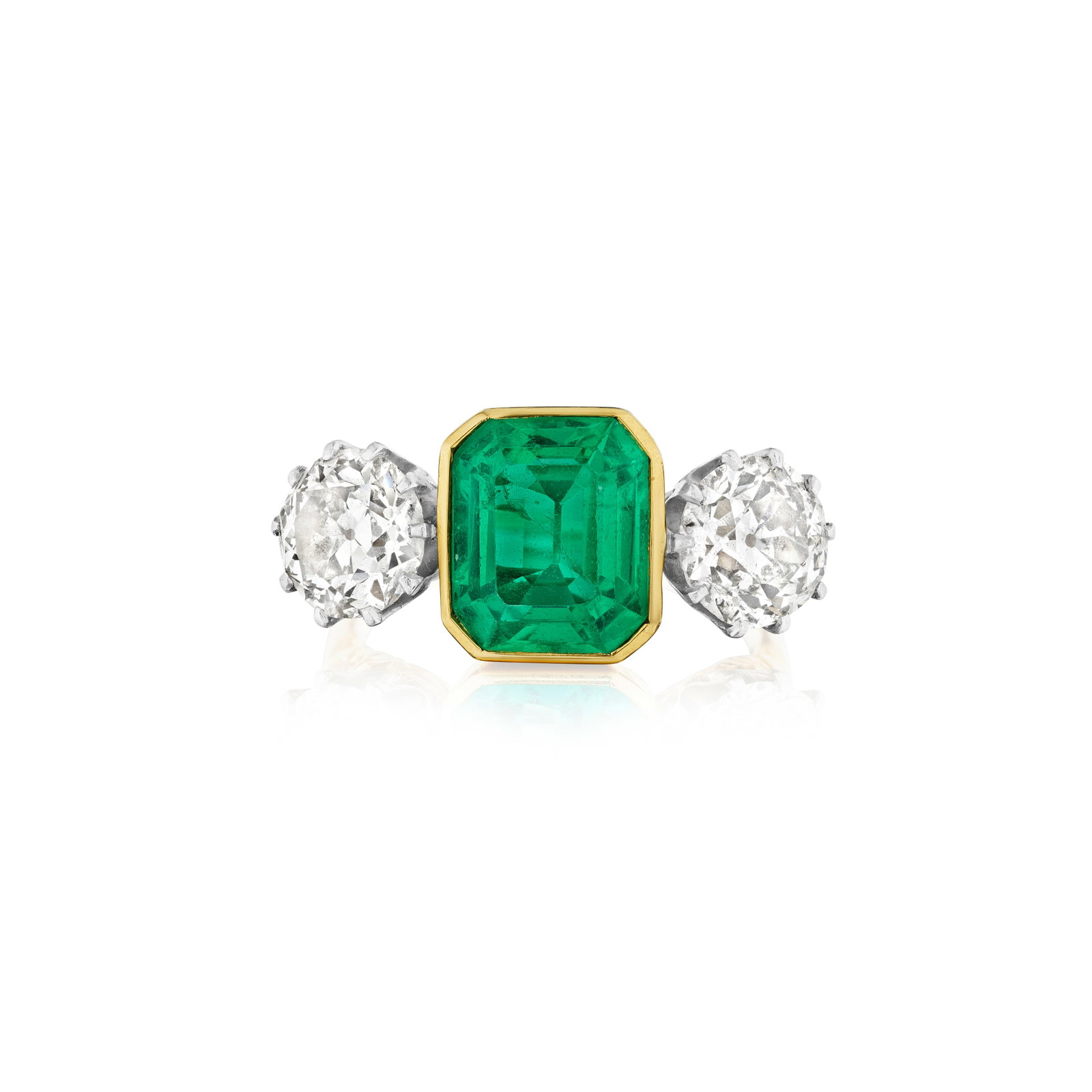 AN EMERALD AND DIAMOND RING: AN EMERALD AND DIAMOND RING Centering an emerald-cut emerald, flanked by two old European-cut diamonds; estimated emerald weight 3.25 carats; estimated total diamond weight 3.30 carats; mounted in 18K
