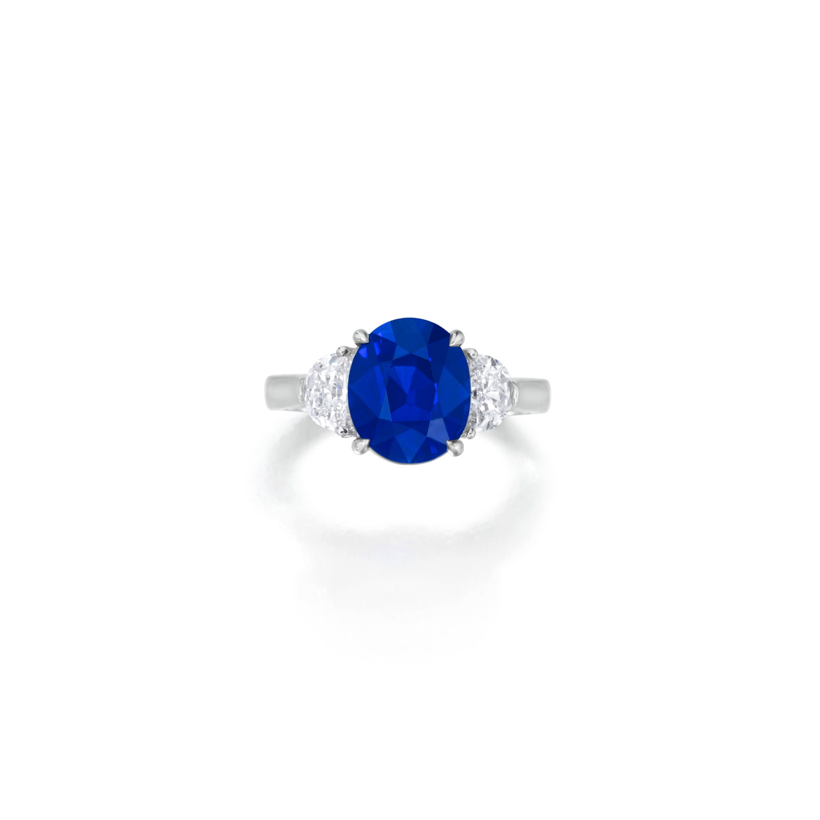 A SAPPHIRE AND DIAMOND RING: A SAPPHIRE AND DIAMOND RING Centering an oval-shaped sapphire, weighing 4.05 carats, flanked by two half moon-shaped diamond; mounted in 18K white gold; size 5 Footnotes: Accompanied by Gübelin