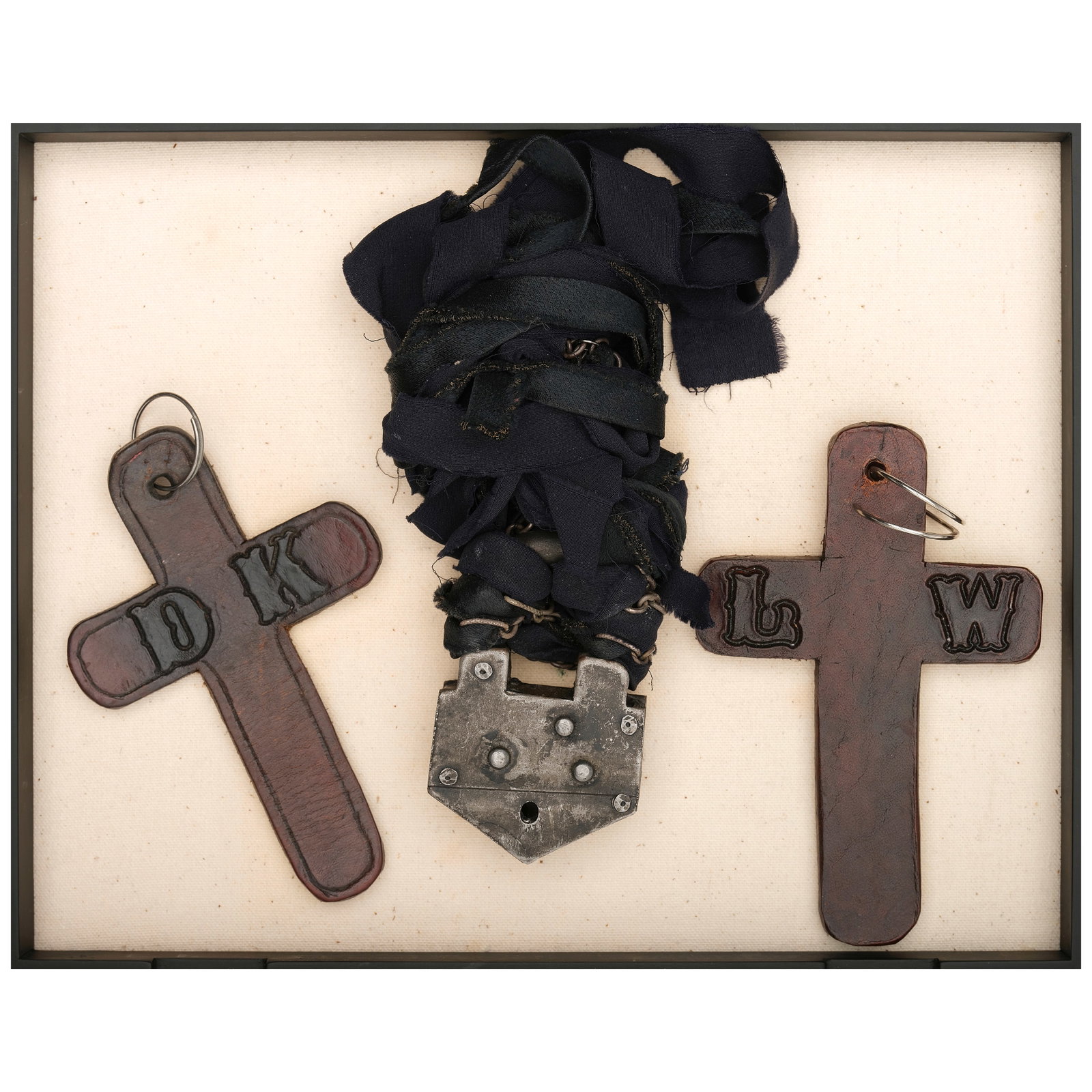 A LARGE METAL LOCK ON BLACK RIBBON: A LARGE METAL LOCK ON BLACK RIBBON Together with two leather crosses branded DK and LW. height of box 2in; width 11 1/2in; depth 9 1/4in Footnotes: The necklace worn on many occasions, including