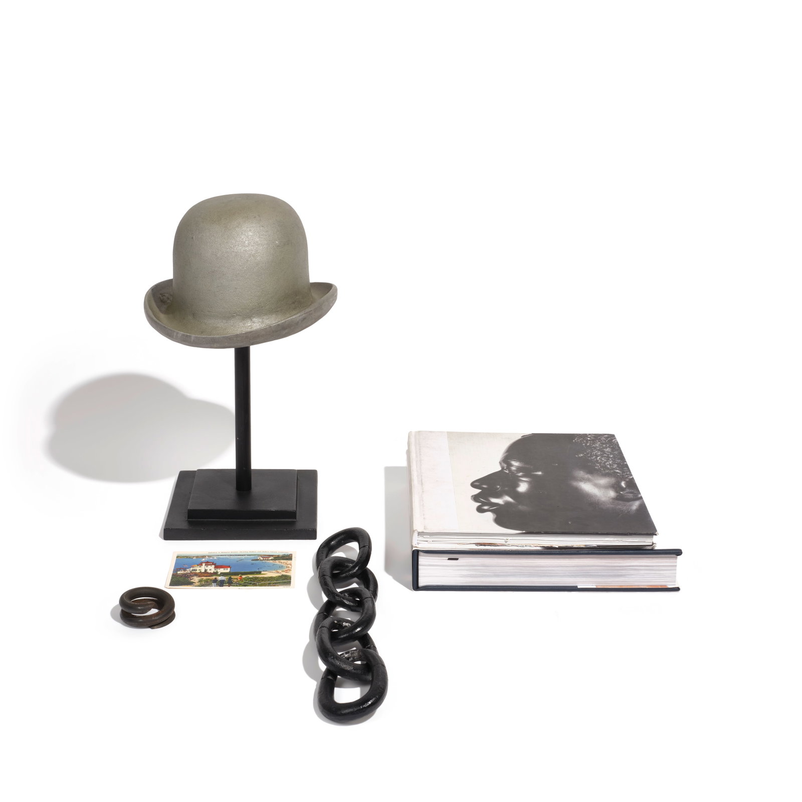 A CURATED SELECTION OF SIX BLACK, GRAY, AND WHITE TABLETOP DECORATIONS: A CURATED SELECTION OF SIX BLACK, GRAY, AND WHITE TABLETOP DECORATIONS Comprising a silvered metal top hat on an integrated black metal stand, a black iron chain, a black iron coil spring, Rover Barki