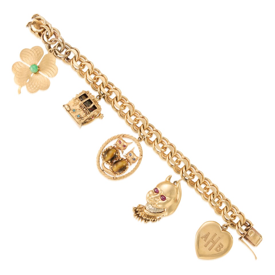 GOLD CHARM BRACELET: GOLD CHARM BRACELET • 12K, 13K, and 14K yellow gold • Five gold charms with jade, ruby, sapphire, and tiger's eye • Heart charm with two portraits • Biggest charm measures 1 1/