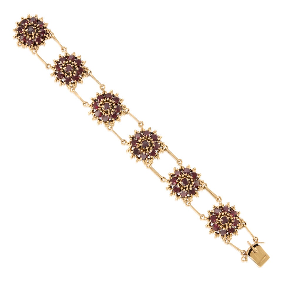 GOLD AND GARNET BRACELET: GOLD AND GARNET BRACELET • 11K, 12K, and 14K yellow gold • Numerous round shaped garnets weighing approximately 2.70 carats total • Length 7 1/2 in. • Estimated gross weight: