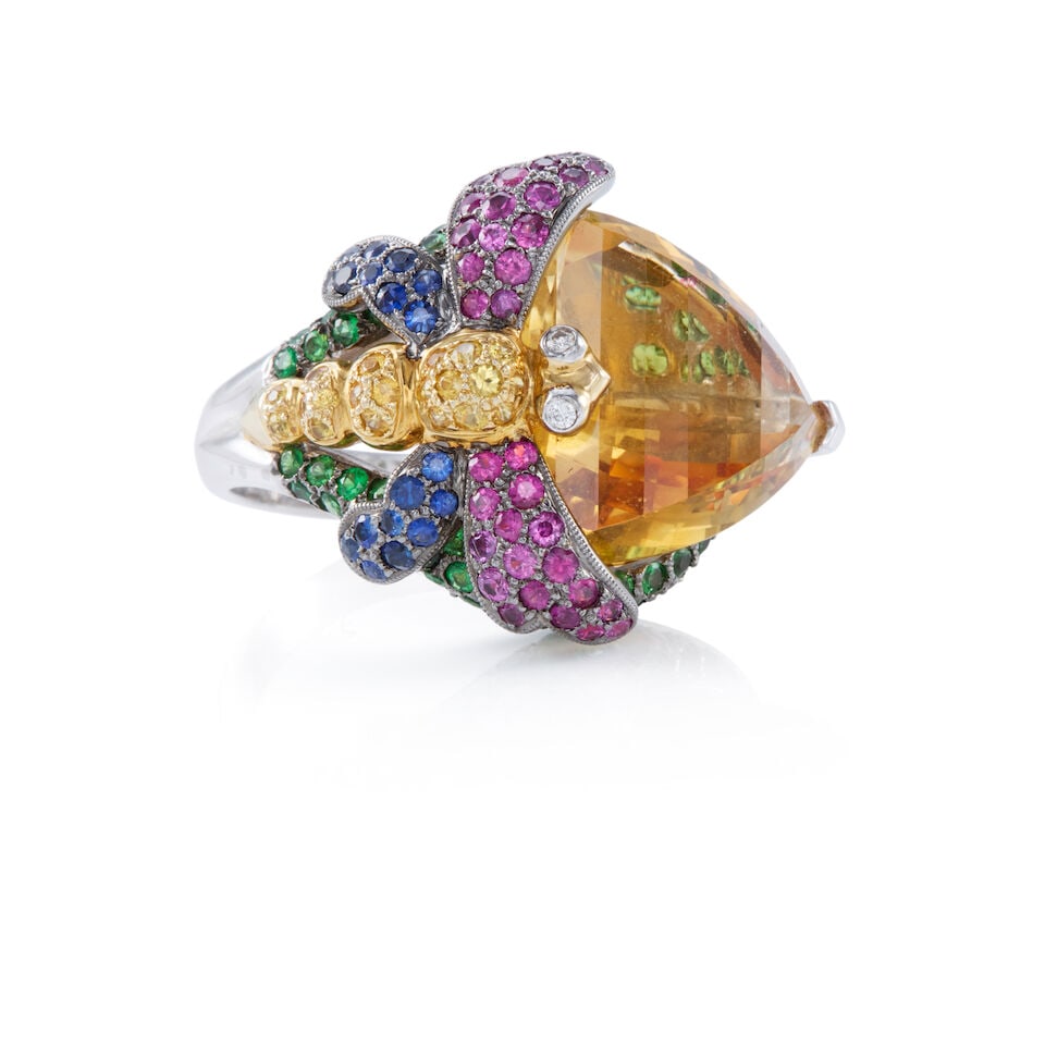 18K GOLD AND GEMSET RING: 18K GOLD AND GEMSET RING • 18K white gold • One triangular shaped citrine measuring approximately 10 carats, with numerous round shaped citrines weighing approximately 0.15 carat total