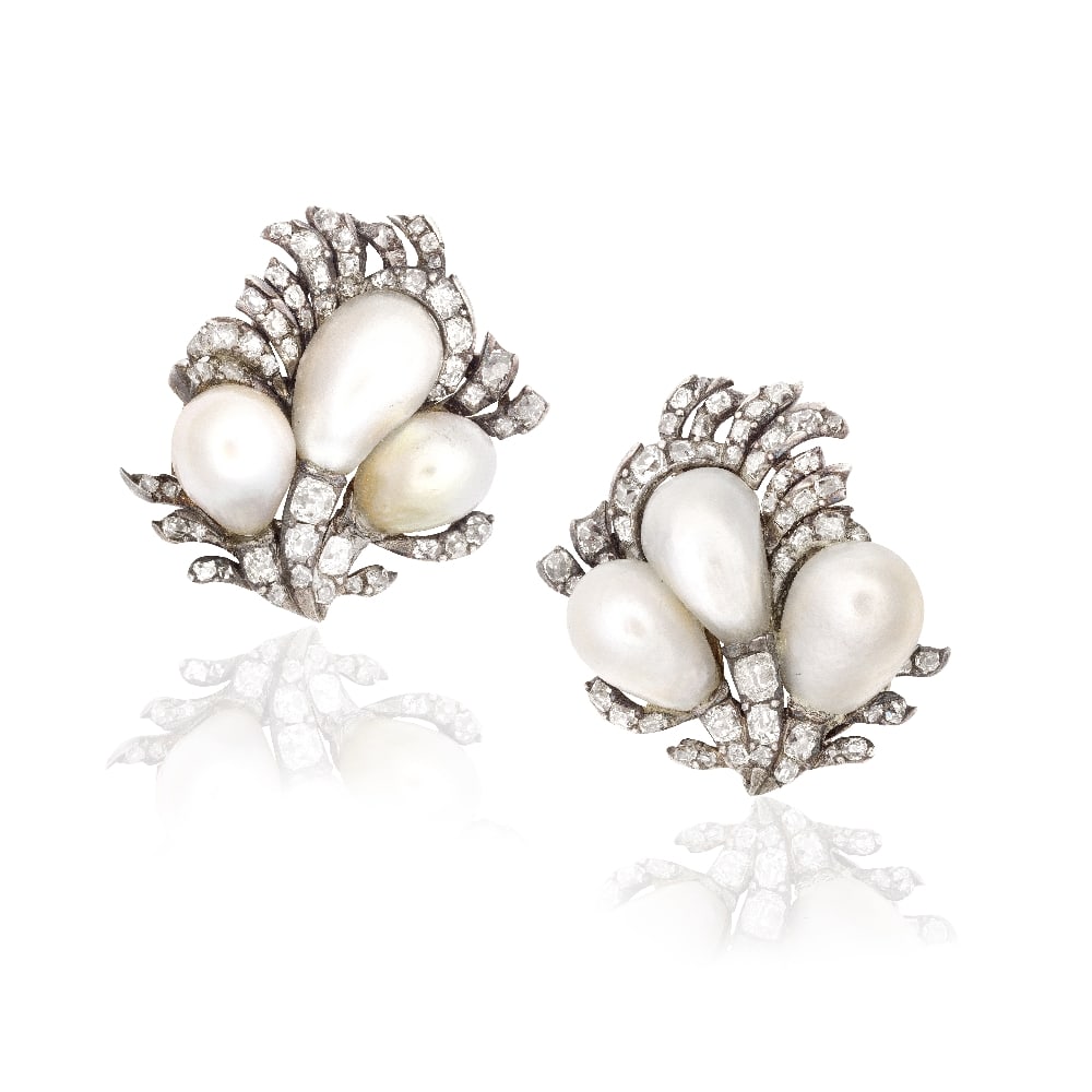 NATURAL PEARL AND DIAMOND EARCLIPS: NATURAL PEARL AND DIAMOND EARCLIPS Each set with baroque-shaped natural pearls, measuring 10.6-13.4mm, within a plume of old cushion-cut diamonds, one later replacement cultured pearl, converted from