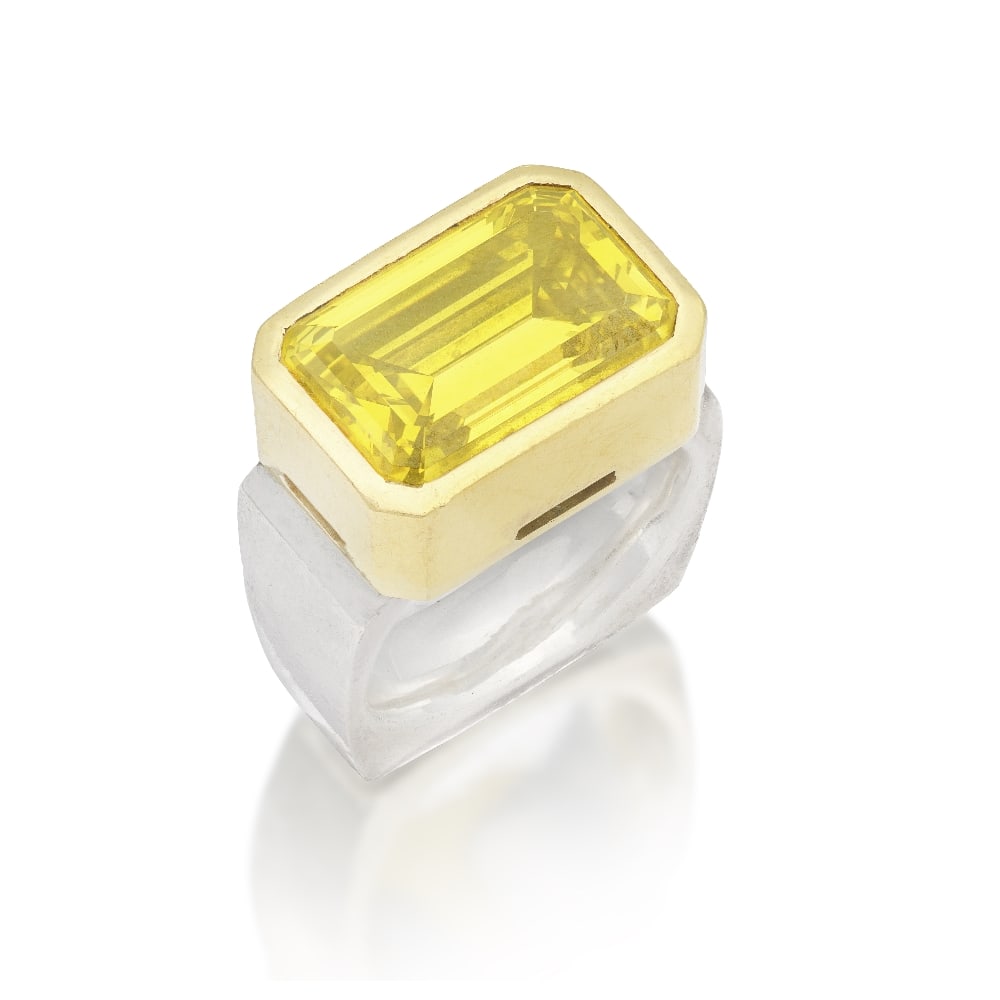 TREATED COLOURED DIAMOND RING: TREATED COLOURED DIAMOND RING The step-cut treated yellow diamond weighing 12.15 carats, mounted in silver and gold, ring size N Footnotes: Property from a Private Collection Accompanied by a report