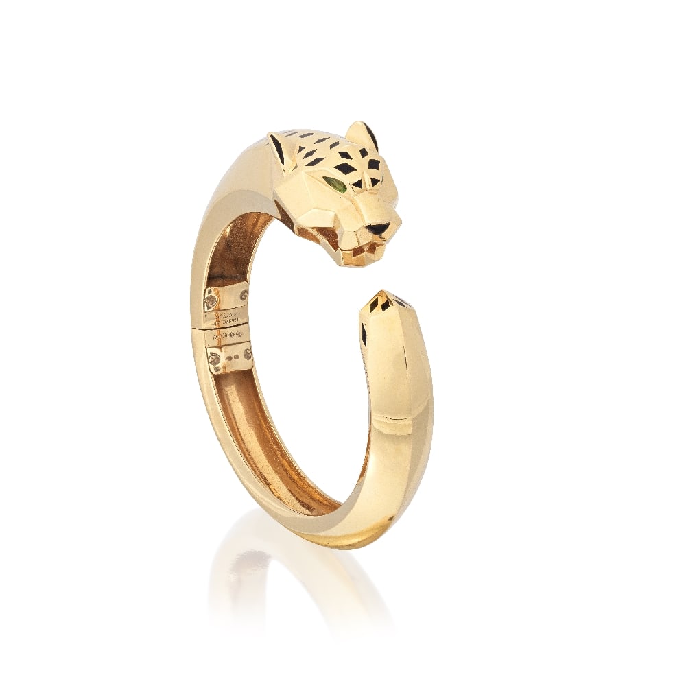 CARTIER: GEM-SET 'PANTHÈRE DE CARTIER' BANGLE: CARTIER: GEM-SET 'PANTHÈRE DE CARTIER' BANGLE The panther with black lacquer spots, pear-cut tsavorite garnet eyes and onyx nose, mounted in 18 carat gold, signed Cartier, numbered OKK924,
