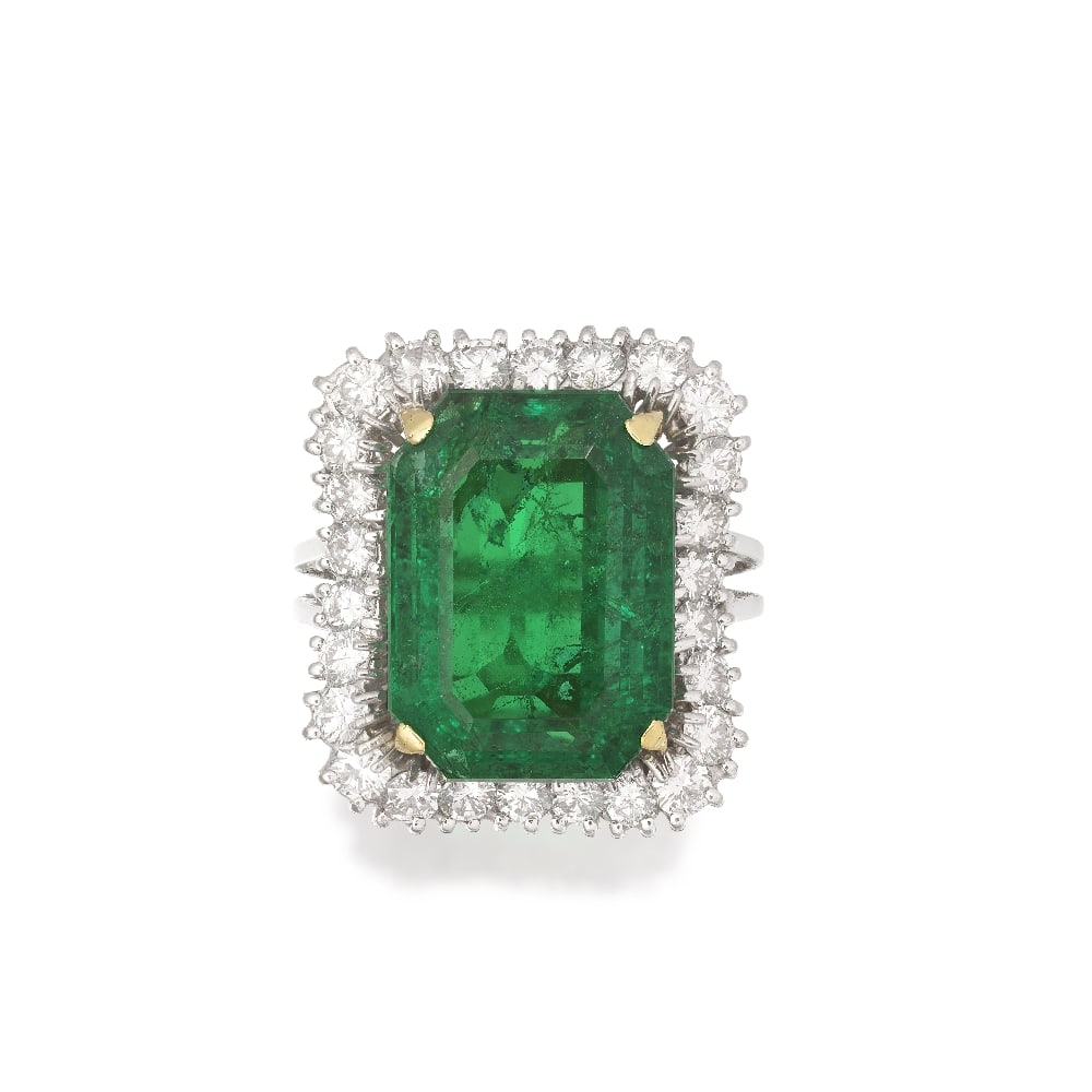 EMERALD AND DIAMOND RING: EMERALD AND DIAMOND RING The octagonal step-cut emerald, weighing approximately 13.60 carats, within an undulating surround of brilliant-cut diamonds, between bifurcated shoulders, diamonds