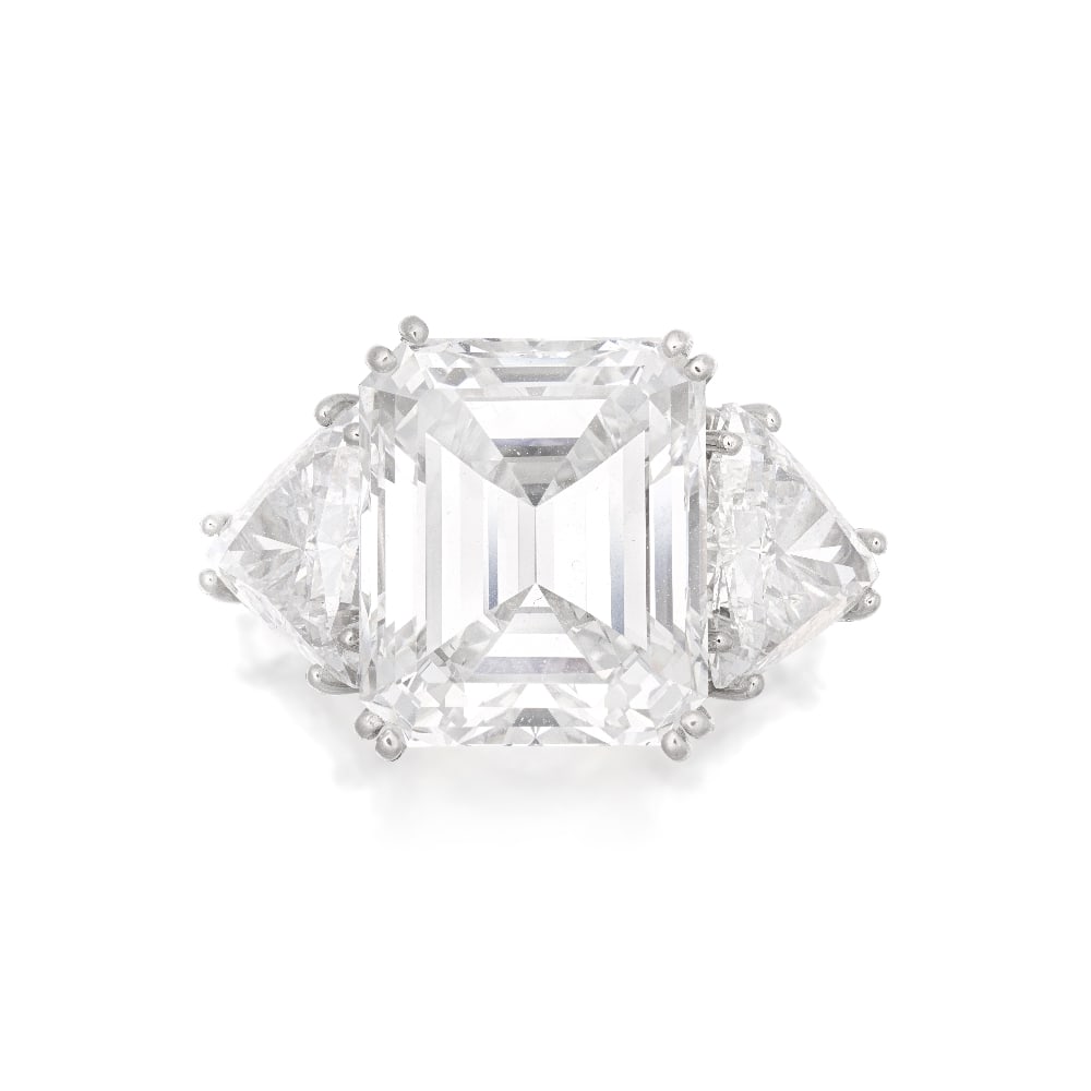 DIAMOND RING: DIAMOND RING The step-cut diamond, weighing 8.54 carats, between trilliant-cut diamond shoulders, trilliant-cut diamonds approximately 1.35 and 1.35 carats, ring size I, cased by Aldao, Madrid