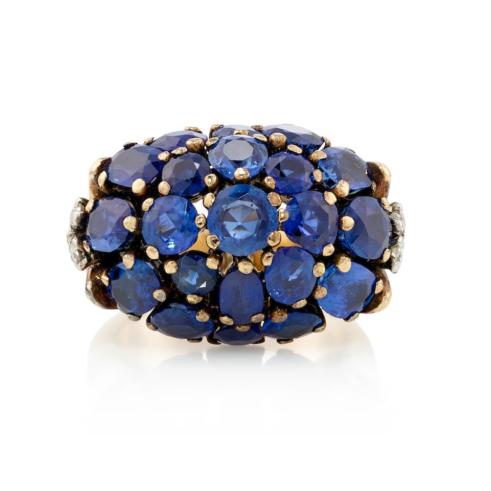 9K GOLD, SAPPHIRE, AND DIAMOND RING: 9K GOLD, SAPPHIRE, AND DIAMOND RING • 9K yellow gold • Numerous round and oval shaped sapphires weighing approximately 5 carats total • 6 round shaped diamonds weighing