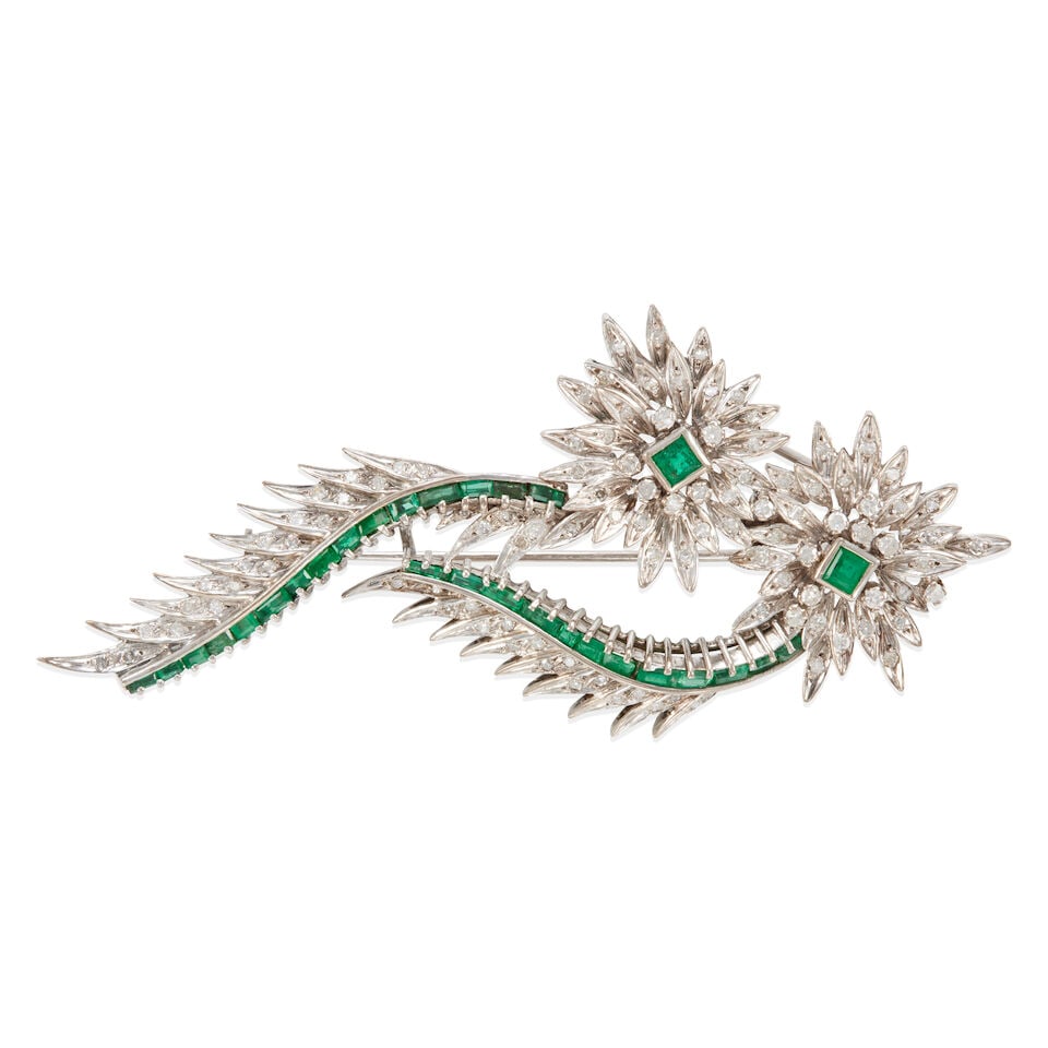 DIAMOND AND EMERALD BROOCH: DIAMOND AND EMERALD BROOCH • White precious metal alloy composed primarily of silver with palladium and minor gold content • Numerous round diamonds of decorative quality • Numerous