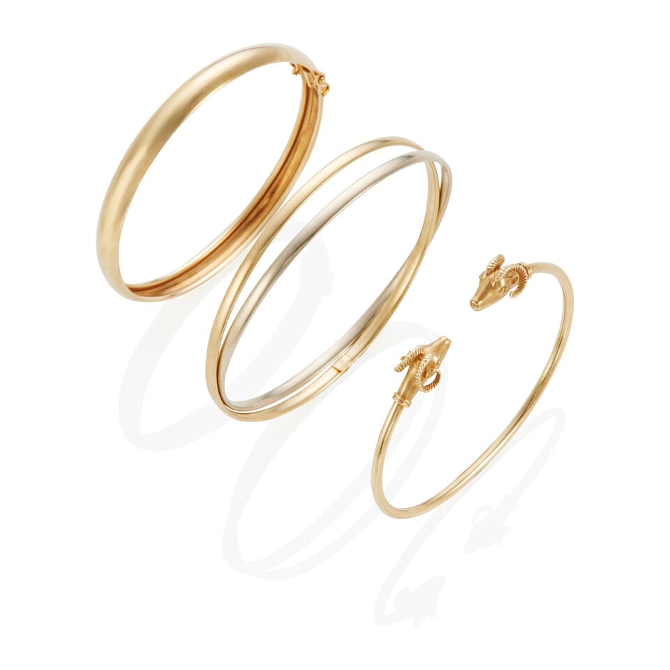 THREE 14K GOLD BANGLE BRACELETS: THREE 14K GOLD BANGLE BRACELETS • One bracelet of 14k yellow gold, inner circumference 7 1/4 in. • One ram bracelet of 14k yellow gold, inner circumference 6 in. • One double bangle 