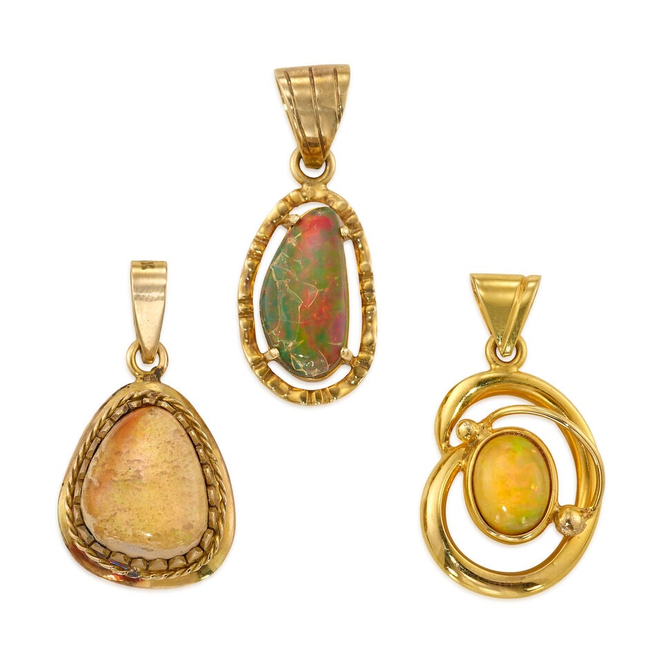 THREE GOLD AND OPAL PENDANTS: THREE GOLD AND OPAL PENDANTS • One 12K yellow gold pendant with an oval shaped opal measuring approximately 10.25mm x 8.02mm x 3.97mm, measures 1 5/16 in. x 3/4 in. • One 10K yellow gold