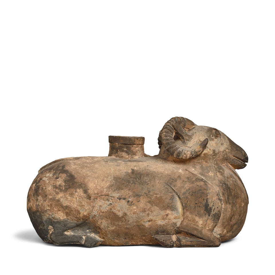 A GRAY POTTERY RAM-FORM VESSEL Han dynasty: A GRAY POTTERY RAM-FORM VESSEL Han dynasty 13 1/2in (35cm) long Footnotes: 漢 灰陶臥羊形尊 Provenance: The Alan and Simone Hartman Collection 來源