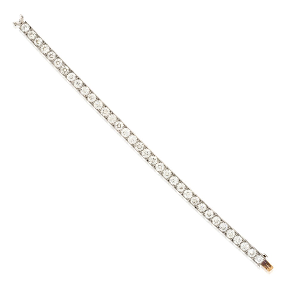 TIFFANY & CO.: AN ART DECO PLATINUM AND DIAMOND LINE BRACELET: TIFFANY & CO.: AN ART DECO PLATINUM AND DIAMOND LINE BRACELET Set with old European-cut diamonds, approximate total weight 12.00 carats, millegrain accents, weight 15.0 dwt, signed Tiffany & Co.,