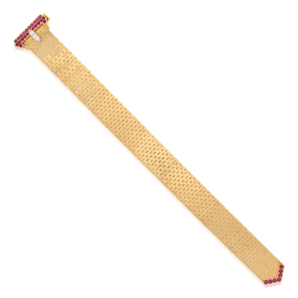 TIFFANY & CO.: A RETRO 14K GOLD, RUBY, AND DIAMOND BUCKLE BRACELET: TIFFANY & CO.: A RETRO 14K GOLD, RUBY, AND DIAMOND BUCKLE BRACELET Composed of brickwork links, with clasp designed as a buckle set with circular-cut rubies and full-cut diamonds, weight 27.1 dwt,