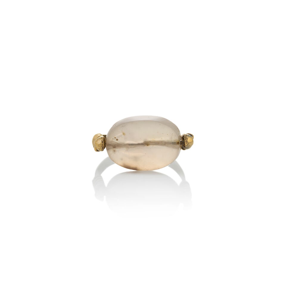 AN ANTIQUE HIGH KARAT GOLD AND HARDSTONE INTAGLIO SWIVEL RING: AN ANTIQUE HIGH KARAT GOLD AND HARDSTONE INTAGLIO SWIVEL RING Centering a hardstone intaglio depicting a figure preparing for battle, swivel set, weight 3.4 dwt, approximately size 5 1/2. For further
