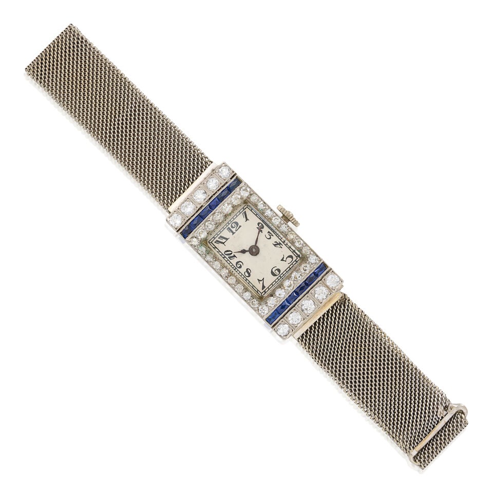 AN ART DECO DIAMOND WRISTWATCH: AN ART DECO DIAMOND WRISTWATCH The platinum case centering a rectangular dial with Arabic numeral indicators framed by old European and single-cut diamonds and channel-set fancy-cut sapphires and synt