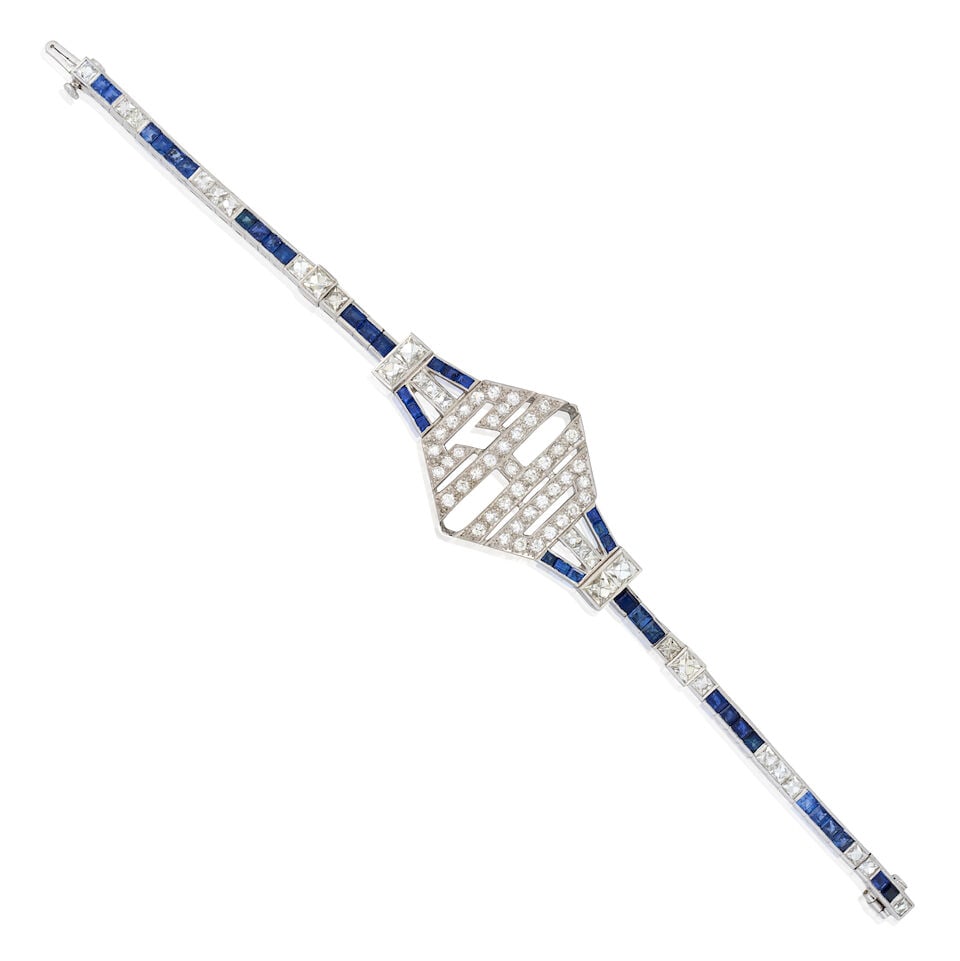 AN EDWARDIAN PLATINUM, SAPPHIRE, AND DIAMOND BRACELET: AN EDWARDIAN PLATINUM, SAPPHIRE, AND DIAMOND BRACELET The central plaque with monogramed initials 'CDH' set with single-cut diamonds, joined to a bracelet of channel-set fancy-cut sapphires and