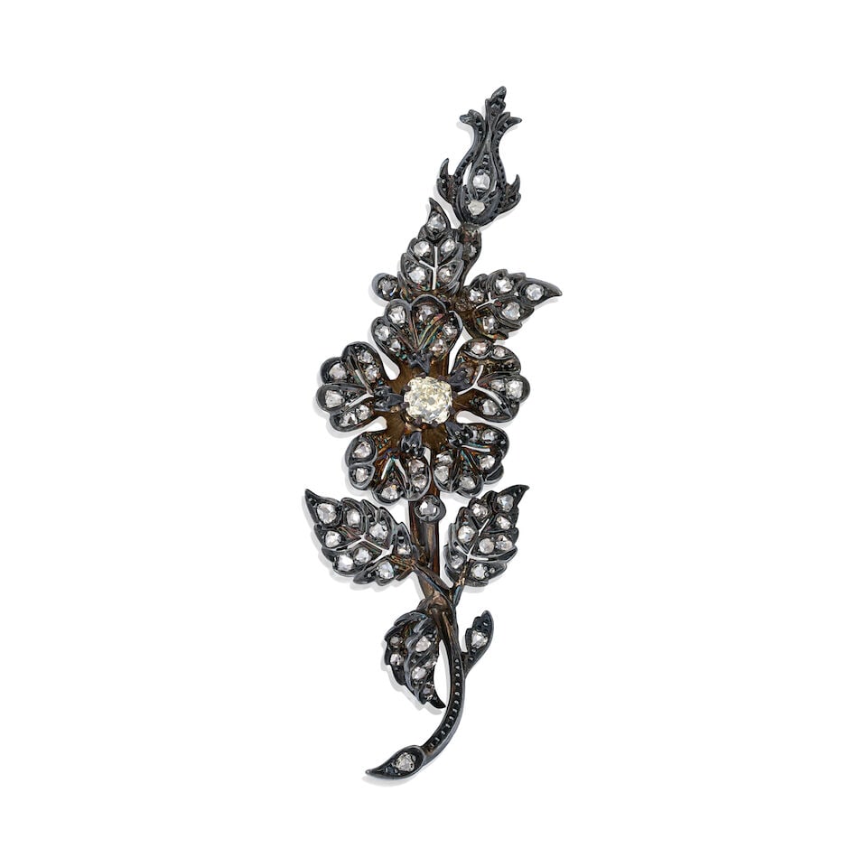AN ANTIQUE DIAMOND SPRAY BROOCH: AN ANTIQUE DIAMOND SPRAY BROOCH The floral spray centering an old mine-cut diamond weighing approximately 0.55 carats, further set with rose-cut diamonds, weighing approximately 0.45 carats,