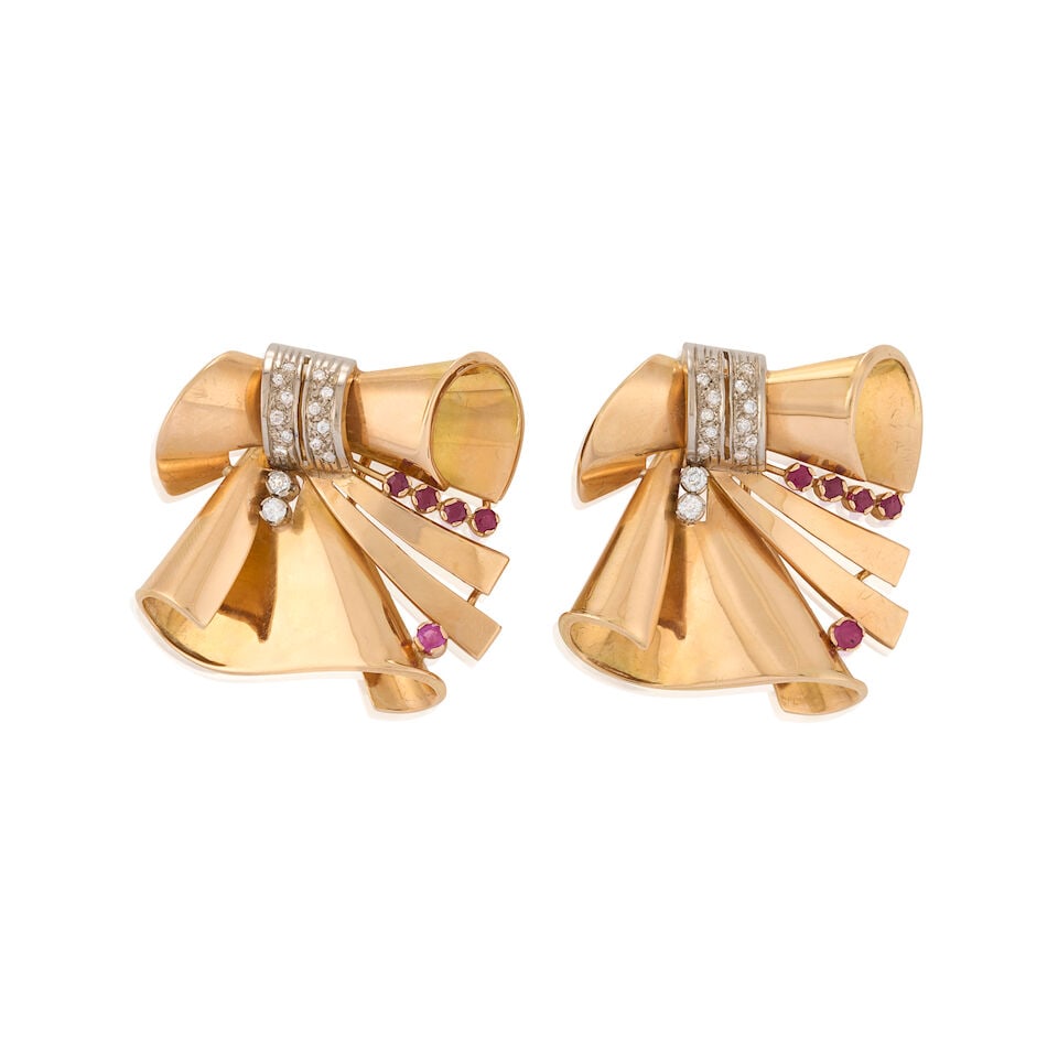 A PAIR OF RETRO 18K GOLD, RUBY, AND DIAMOND CLIP BROOCHES: A PAIR OF RETRO 18K GOLD, RUBY, AND DIAMOND CLIP BROOCHES The scrolled ribbon forms set with circular-cut rubies and old European-cut diamonds, with findings for brooch conversion, weight 23.7 dwt,