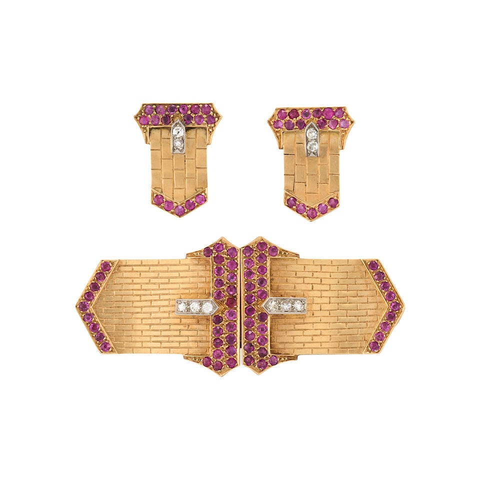 A PAIR OF RETRO GOLD, RUBY, AND DIAMOND CLIP BROOCHES AND EARRINGS: A PAIR OF RETRO GOLD, RUBY, AND DIAMOND CLIP BROOCHES AND EARRINGS The clips designed as buckles set with circular-cut rubies and transitional and full-cut diamonds, with findings for brooch conversio