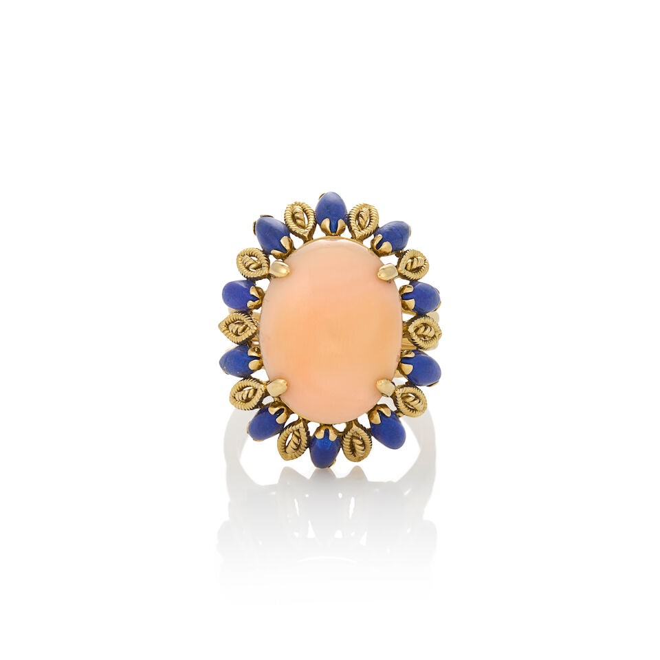 A GOLD, LAPIS LAZULI, AND CORAL RING: A GOLD, LAPIS LAZULI, AND CORAL RING Centering an oval cabochon angel skin coral, measuring approximately 17.60 x 13.55 x 6.25 mm, with lapis lazuli and gold ropework border, weight 8.4 dwt, approxima