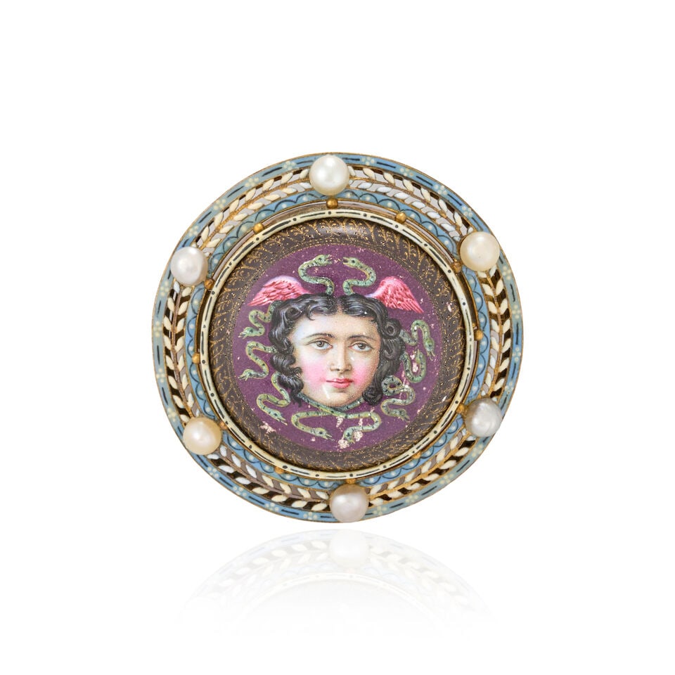 AN ANTIQUE REVIVALIST GOLD, ENAMEL, AND PEARL BROOCH: AN ANTIQUE REVIVALIST GOLD, ENAMEL, AND PEARL BROOCH Centering a polychrome enamel head of Medusa within an foliate openwork frame of blue, white, and black enamel, set with button pearls, weight 9.5