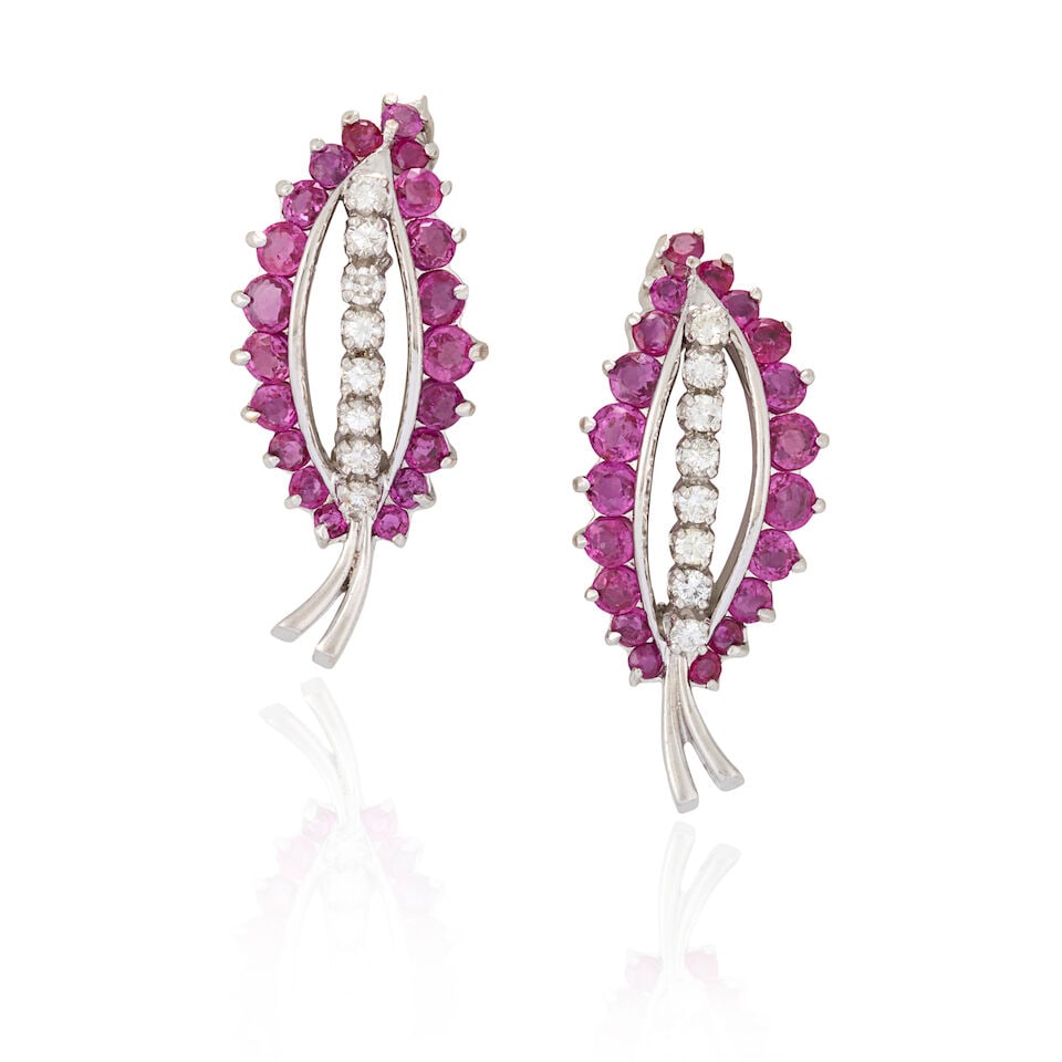 A PAIR OF 14K WHITE GOLD, RUBY, AND DIAMOND EARCLIPS: A PAIR OF 14K WHITE GOLD, RUBY, AND DIAMOND EARCLIPS Designed as leaves set with circular-cut rubies and full-cut diamonds, weight 5.9 dwt, length 1 1/4 in. For further information on this lot please