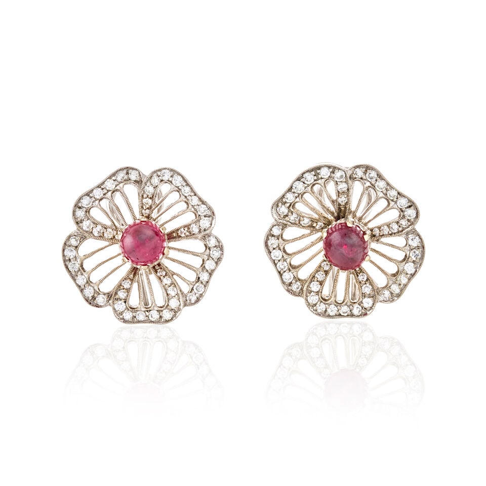 A PAIR OF 18K WHITE GOLD, RUBY, AND DIAMOND EARRINGS, CIRCA 1950s: A PAIR OF 18K WHITE GOLD, RUBY, AND DIAMOND EARRINGS, CIRCA 1950s Designed as flowers, each centering a ruby cabochon framed by pierced petals set with full-cut diamonds, approximate total diamond