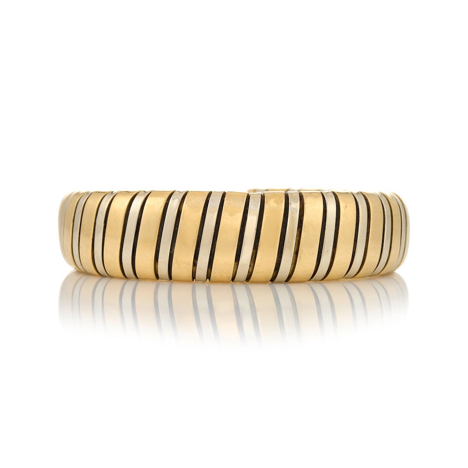 CARLO WEINGRILL: AN 18K BI-COLOR GOLD CUFF BRACELET, ITALY: CARLO WEINGRILL: AN 18K BI-COLOR GOLD CUFF BRACELET, ITALY The flexible cuff in yellow and white gold, weight 32.1 dwt, maker's mark for Carlo Weingrill, Italian registry mark, interior circumference
