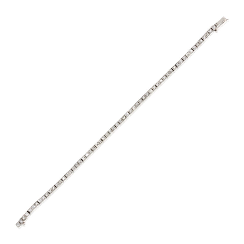 A PLATINUM AND DIAMOND BRACELET: A PLATINUM AND DIAMOND BRACELET Set with French-cut diamonds, approximate total weight 5.00 carats, engraved foliate motifs and millegrain accents, weight 10.8 dwt, length 7 1/8 in. For further inform