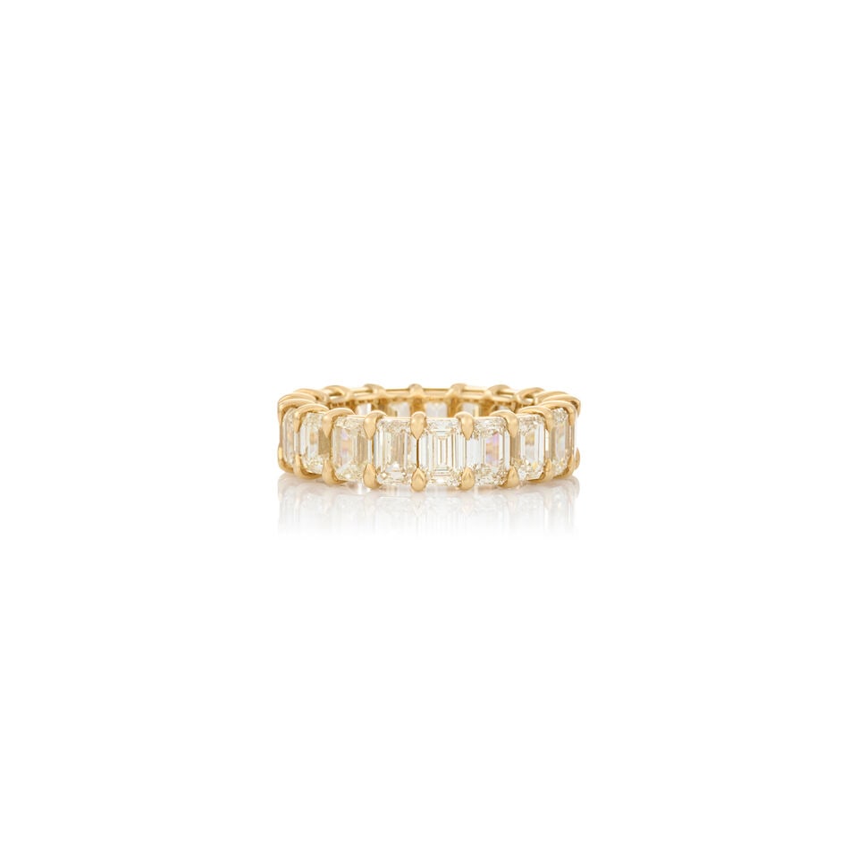 AN 18K GOLD AND DIAMOND BAND: AN 18K GOLD AND DIAMOND BAND Set with emerald-cut diamonds, approximate total weight 6.00 carats, weight 3.0 dwt, between size 6 1/4 and 6 1/2. For further information on this lot please visit